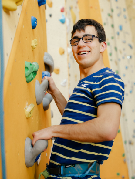 Ein junger Mann klettert in der Kletterhalle