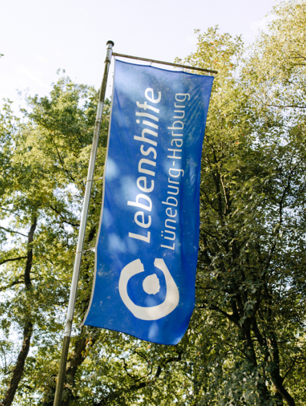 Eine Lebenshilfe-Fahne weht im Wind.