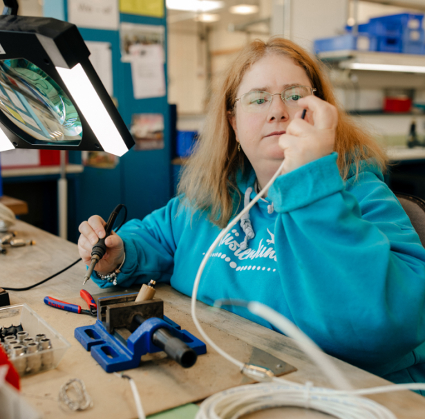 Eine Frau prüft ein Kabel.