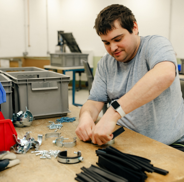 Ein junger Mann arbeitet in der Abteilung Metallbearbeitung. 