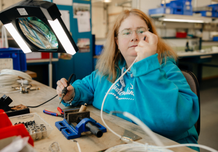 Eine Frau prüft ein Kabel.
