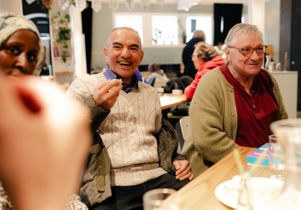 DünAmo Café: zwei Männer sitzen am Tisch, unterhalten sich und lächeln.