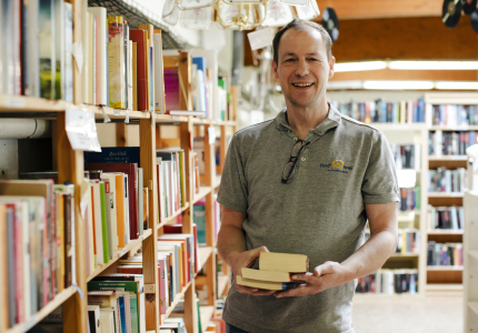 Ein Mann bietet Bücher zum Verkauf an