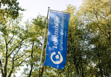Eine Lebenshilfe-Fahne weht im Wind.