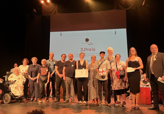 Die Theatergruppe steht bei der Preisverleihung auf der Bühne. 