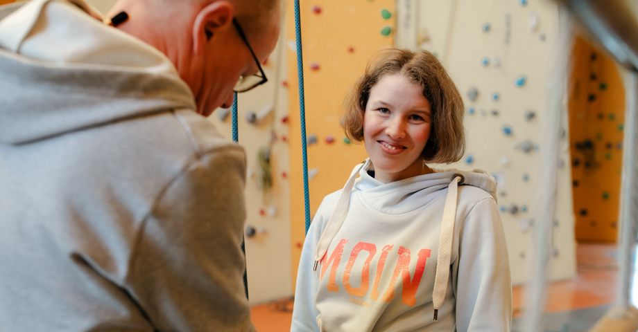 Junge Frau wird fürs Klettern vorbereitet.
