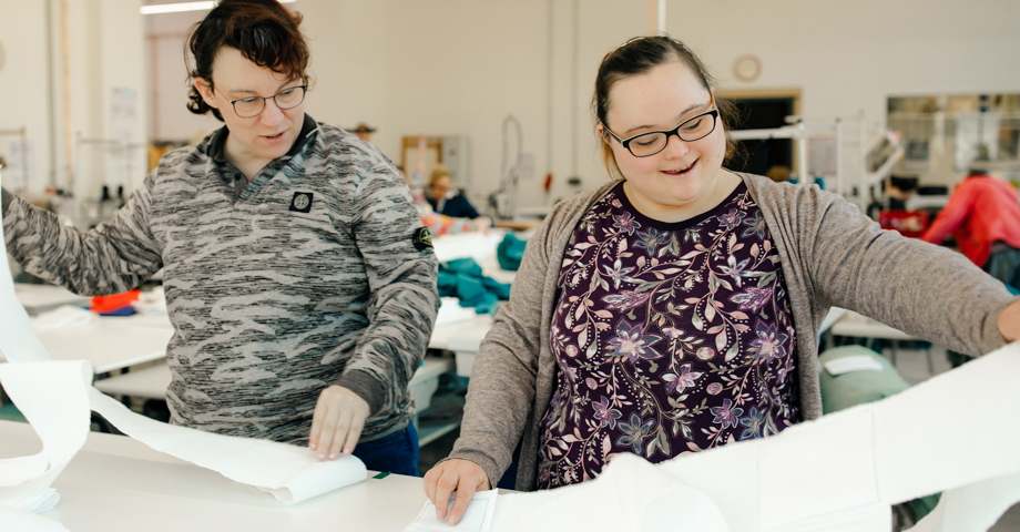 Zwei Frauen arbeiten in der Textinäherei. 