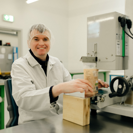 Eine Person arbeitet in der Lebensmittelverpackung. 